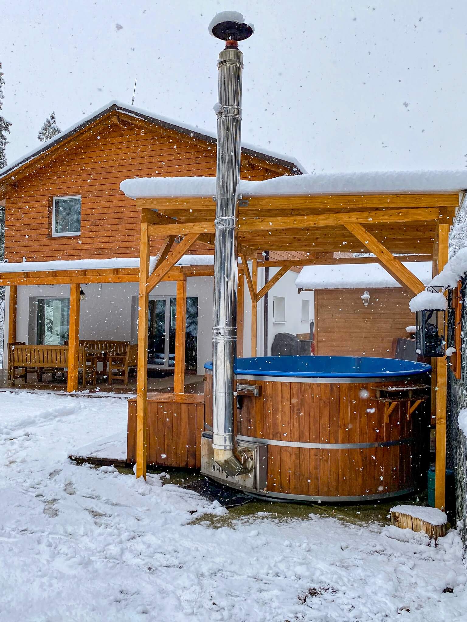 Zasnežená kúpacia kada a v pozadí chata Ester